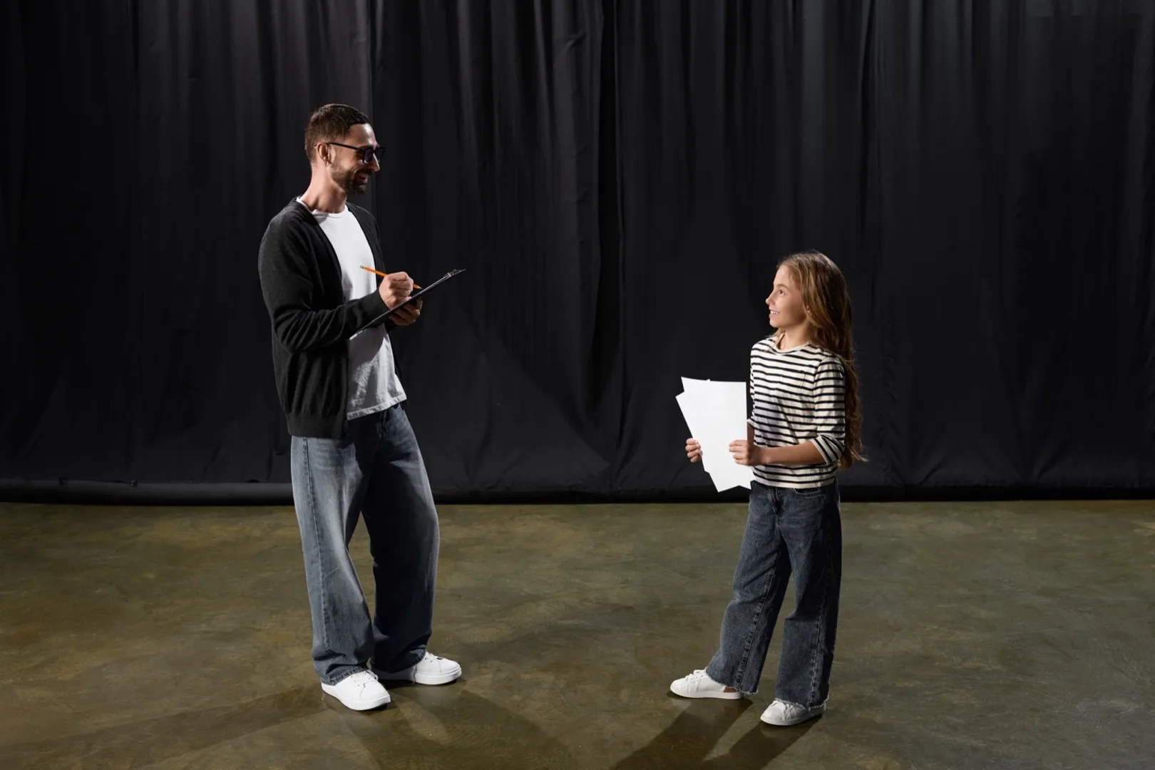An acting coach guiding a student in a theatre